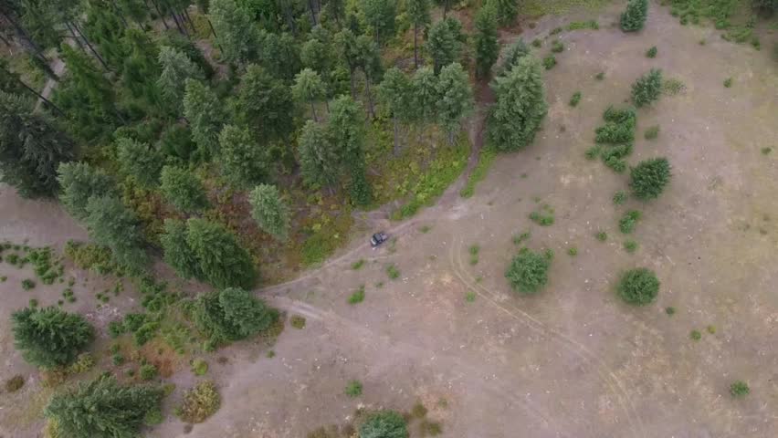 Aerial drone video of a 4-wheeler riding through pine woods on rugged trails outside Colville, Washington, with views of the Northeast Cascades and Stevens County terrain.