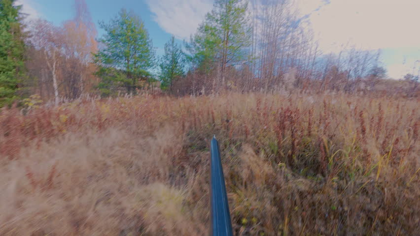 Autumn hunting in the forest. A hunter with a double-barrelled rifle sneaks up on the game. A man hunts an animal in the taiga.