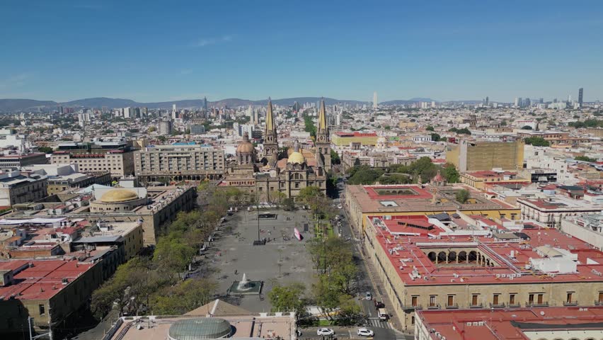 Aerial footage advancing above Plaza Tapatia in Guadalajara, Jalisco, showing the iconic cathedral, plaza, and urban skyline around it