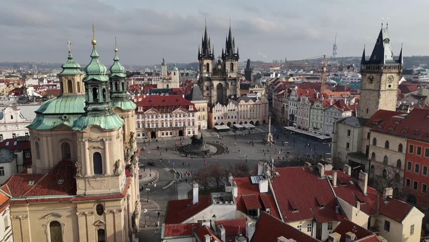 Drone footage over Prague’s Old Town Square showing St. Nicholas Church, Tyn Church, and Astronomical Clock, revealing stunning baroque and gothic architecture