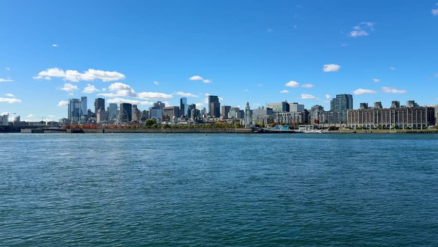 Montreal, Canada - October 08, 2025: Montreal skyline photographed from Parc Jean-Drapeau. The St. Lawrence River in the foreground.