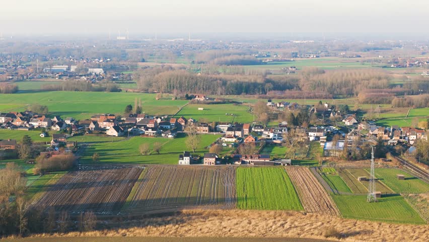 village merchtem belgium rural electric supply lines empty green fields windmills visible horizon scenic urban area infrastructure long aerial view