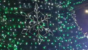 Large glowing snowflake LED light animation turning on as part of Christmas tree illumination during winter holidays. - Powered by Shutterstock - Get 15% off with code: PIKWIZARD15