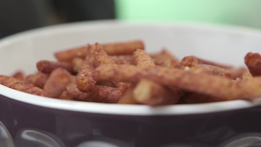 Close-up of pretzels in a bowl with chocolate being poured over