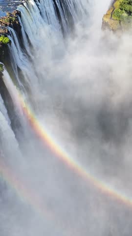 Rainbow In Waterfall At Victoria Falls In Matabeleland North Zimbabwe. Giant Waterfalls. Nature Landscape. Victoria Falls At Matabeleland North Zimbabwe. Zambezi River. Travel Scenery.