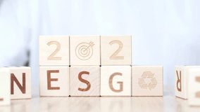 A person arranges wooden blocks displaying goals for 2026. The blocks feature various symbols and letters, illustrating a method for organizing and visualizing aspirations - Powered by Shutterstock - Get 15% off with code: PIKWIZARD15