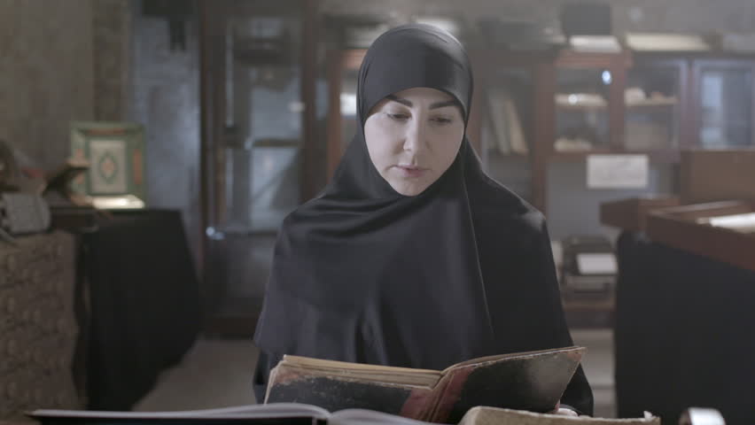 A muslim female wearing hijab reads a book in an old library - Powered by Shutterstock - Get 15% off with code: PIKWIZARD15
