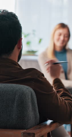Psychologist, woman and man with consultation, talk and notes for mental health assessment in office. People, therapist and discussion with patient, questions and insight for wellness at clinic