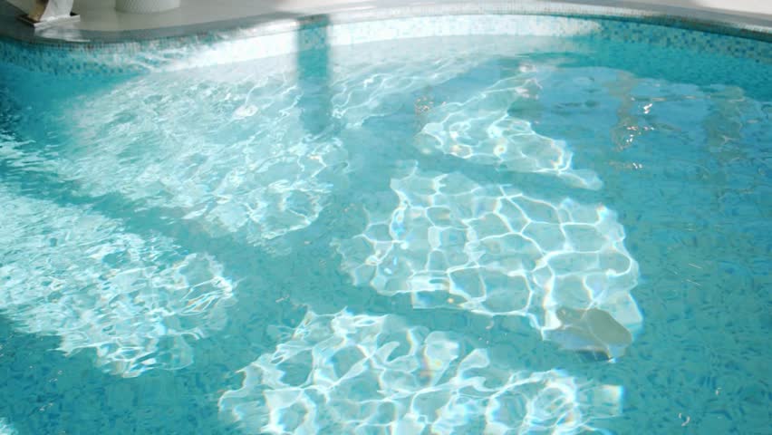 Aerial top down view of swimming pool water surface. The camera flies over the water