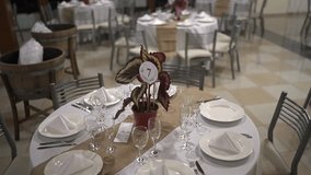 A close-up of an elegant, rustic-chic table setting for a wedding reception, featuring a potted plant centerpiece, a burlap runner, and formal place settings for guests. - Powered by Shutterstock - Get 15% off with code: PIKWIZARD15