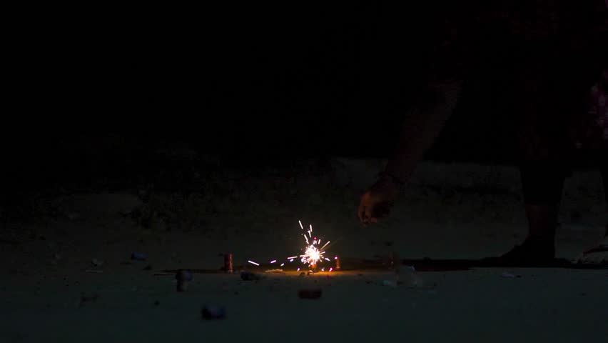 Close up of girl hand lighting up a firecrackers during Diwali festival in India. Indian Hindu woman celebrating Diwali. Diwali background. Fireworks during Diwali. 