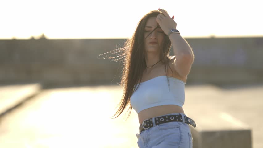 Beautiful young woman dancing outdoors at sunset