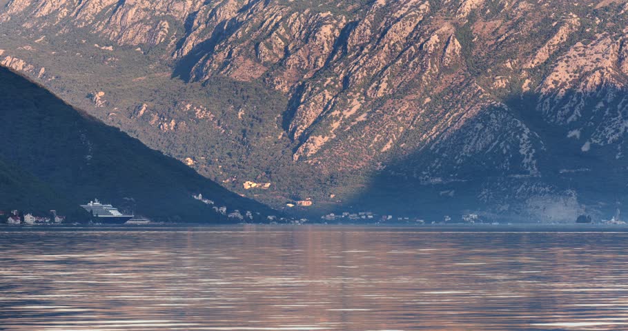 Cruise ship  enters the calm Bay of Kotor in Montenegro early in the morning, reflecting on still waters. Time lapse
