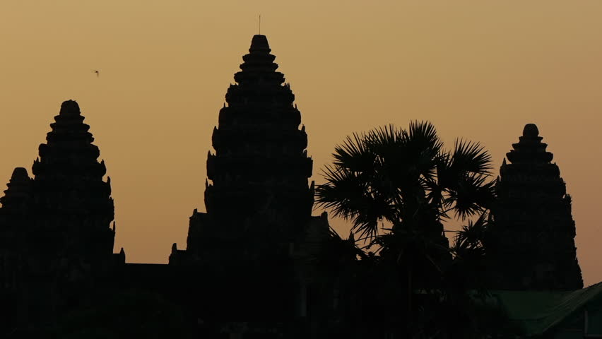 Pan across Angkor Wat ruins at sunrise