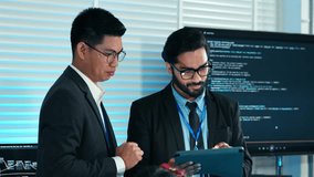 Indian IT manager analyzing and reviewing code on tablet with coworker in the office. Developer planning software development. Team brainstorming project. Professional tech programmer team - Powered by Shutterstock - Get 15% off with code: PIKWIZARD15