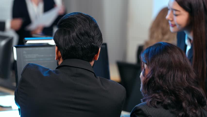 A diverse team of software developers examining computer code on a monitor, focusing on debugging or code review. Mentorship, technical training. Developing application program, Cybersecurity center - Powered by Shutterstock - Get 15% off with code: PIKWIZARD15
