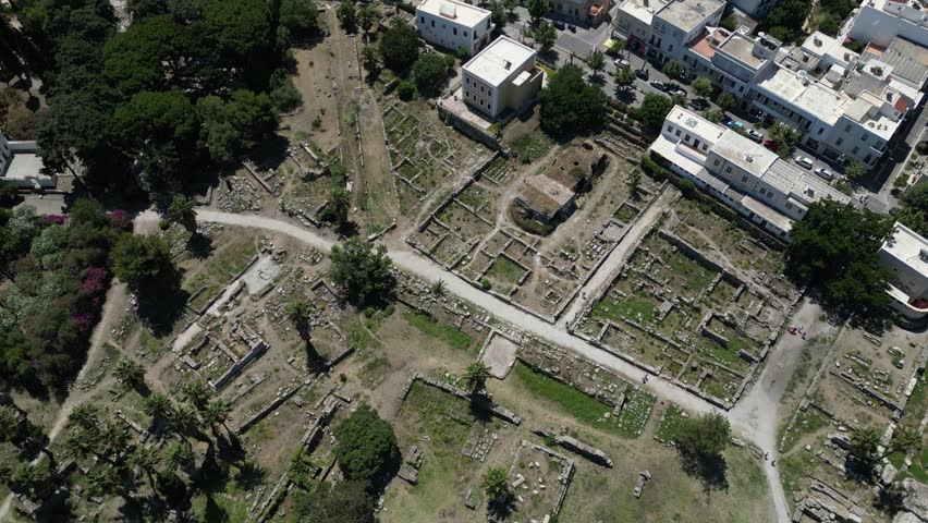Aerial view of old ruins juxtaposed against newer buildings, blending the ancient with the modern in a textured landscape, Kos, Greece.