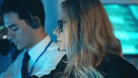 Call center woman wearing a headset works late in a tech office. IT professional providing online customer service or participating in an intense remote video conference call - Powered by Shutterstock - Get 15% off with code: PIKWIZARD15