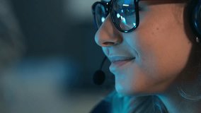 A close up of a smiling female customer service agent or call center employee wearing a headset. Online support, technical assistance, and professional digital communication during a night shift - Powered by Shutterstock - Get 15% off with code: PIKWIZARD15