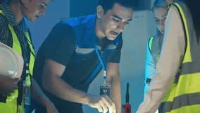 A multiethnic team of dedicated engineers and technicians is holding an intense late-night meeting in an industrial office. Reviewing plans or data, collaborative energy, problem-solving project - Powered by Shutterstock - Get 15% off with code: PIKWIZARD15