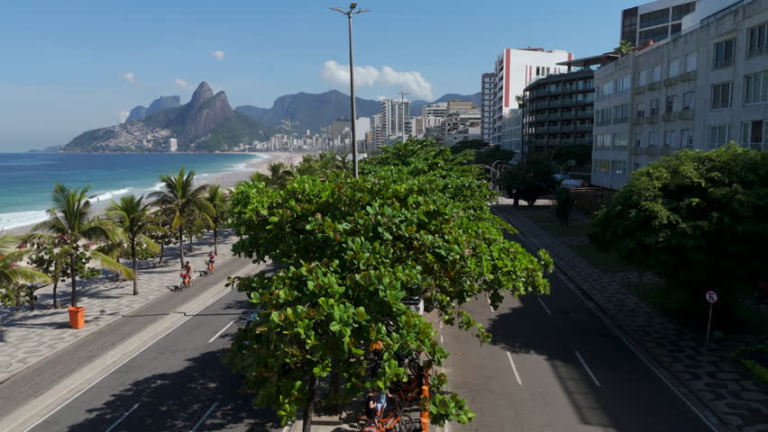 Aerial view of famous Ipanema Beach, lined with palm trees on a bright, sunny day in Rio de Janeiro, Brazil.