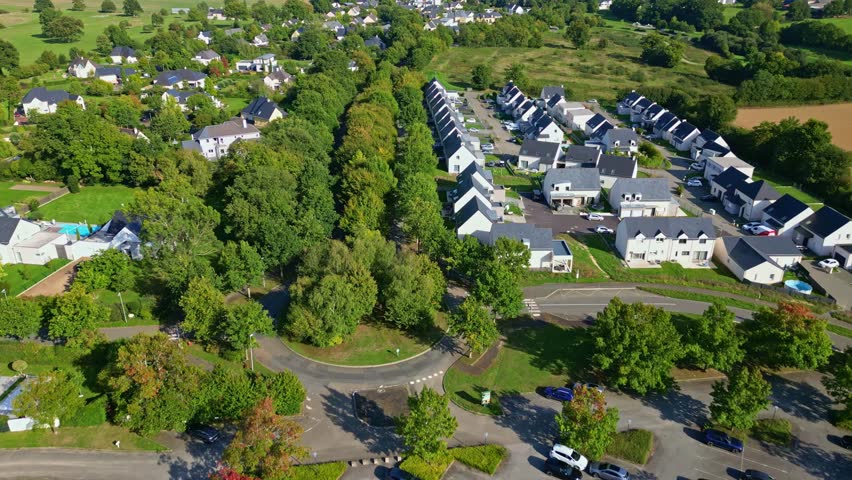 Residential house with garden and driveway surrounded by trees in quiet suburb, drone aerial overview