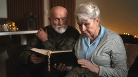 Couple in their 80s reading Bible with beads at home, spiritual family pastime - Powered by Shutterstock - Get 15% off with code: PIKWIZARD15