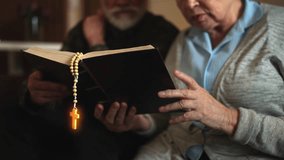 Elderly couple reading Bible with glowing cross, faith and power of prayer - Powered by Shutterstock - Get 15% off with code: PIKWIZARD15