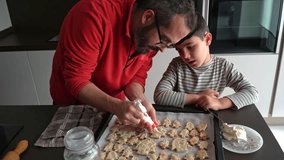 Father and son decorating Christmas cookies together with pastry bag - Powered by Shutterstock - Get 15% off with code: PIKWIZARD15
