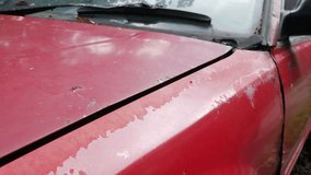 Severe rust corrosion and peeling paint damage on red car hood edge above headlight showing metal deterioration - Powered by Shutterstock - Get 15% off with code: PIKWIZARD15