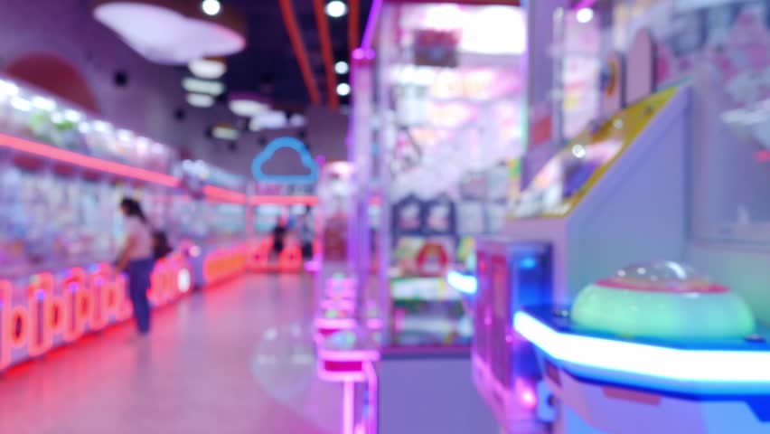 Vibrant Arcade Claw Machine Games with Glowing LED Lights in Indoor Amusement Venue
