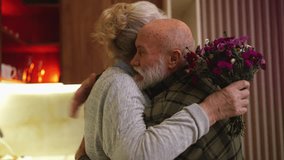 Loving elderly husband giving flowers to wife at home, romantic family surprise - Powered by Shutterstock - Get 15% off with code: PIKWIZARD15
