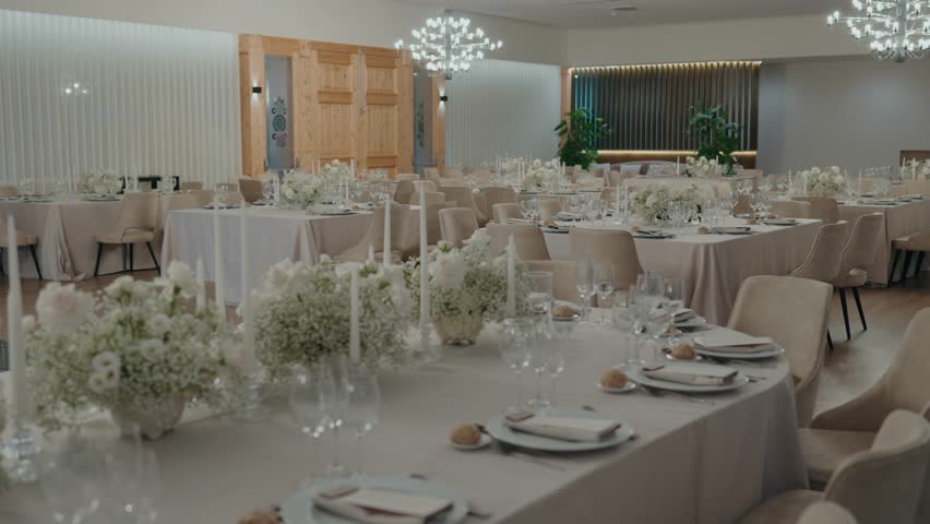 Luxury indoor wedding venue with white floral arrangements and candles
