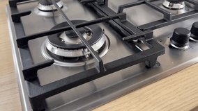 Modern gas stove with blue flame, hand adjusting burner knob, home cooking safety and efficiency, contemporary kitchen appliance, energy sustainability - Powered by Shutterstock - Get 15% off with code: PIKWIZARD15