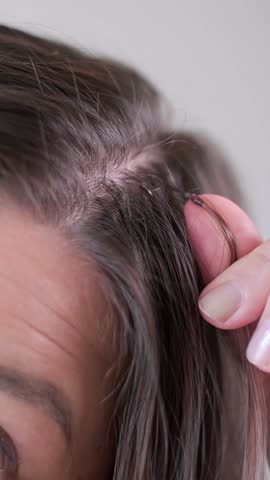 Thin capsules for seamless hair extensions on dark strands professional hairstyling in modern beauty salon