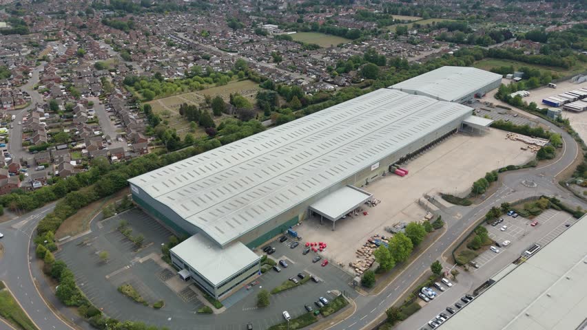 Aerial drone footage of industrial estate with warehouses and distribution facilities in Raunds United Kingdom