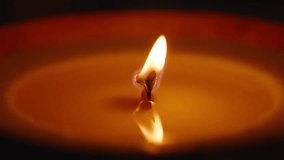 Candle Flame Reflecting Clearly on Melted Wax Surface with Wooden Wick in Focus, Eye-Level Shot, Warm Lighting, Relaxation Concept. - Powered by Shutterstock - Get 15% off with code: PIKWIZARD15
