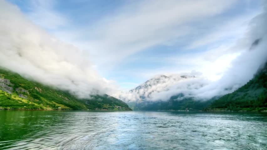 Scenic view of a fjord in Norway with mountains and clouds on a sunny day