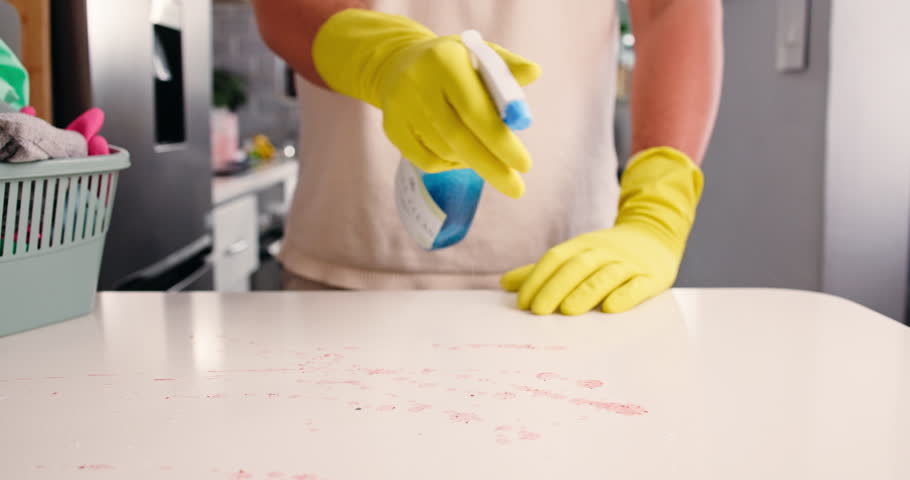 Hands, man and clean with spray on kitchen counter, hygiene and home maintenance to prevent germ spread. Disinfectant tools, surface cleaner and housekeeper with sanitize tabletop, tidy and wipe dirt