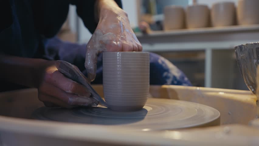 Ceramic Artist Smoothing Clay Cup on Pottery Wheel