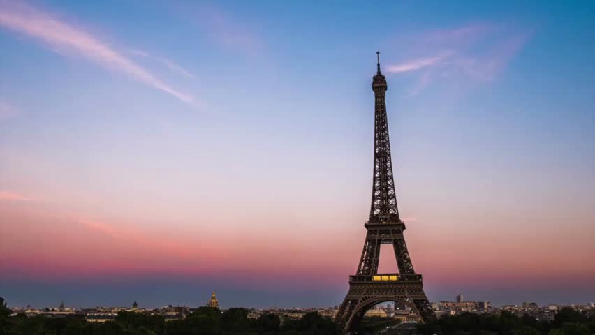 the Eiffel Tower at night in Paris. Eiffel Tower in evening time. Remote silhouette of the Eiffel Tower without lighting against dark sky. Iconic symbol of Paris, famous historical landmark in France.
