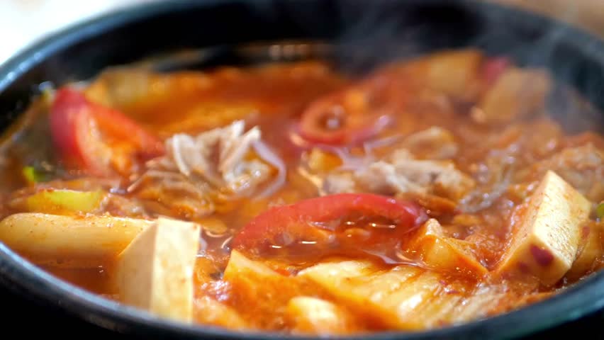 Budae jjigae is korean traditional food. It is loaded with Kimchi, spam, sausages, noodles. Korean hot pot food style. Kimchi Jjigae or Kimchi Soup, Korean Popular Recipe with hot bowl boiling.