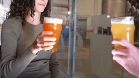 Happy young couple clinking glasses of fresh craft beer at a microbrewery. They are toasting and celebrating with pints of ale and lager - Powered by Shutterstock - Get 15% off with code: PIKWIZARD15