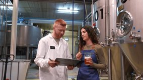 Young female brewmaster tasting craft beer with a male quality control inspector. Colleagues discussing the beverage's flavor and aroma - Powered by Shutterstock - Get 15% off with code: PIKWIZARD15