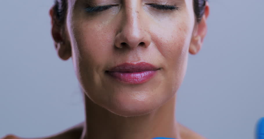 Hands, lip filler injection and woman in studio for plastic surgery, beauty or smile on background. Mature person, surgeon and happy with syringe for cosmetics, patient or collagen for transformation