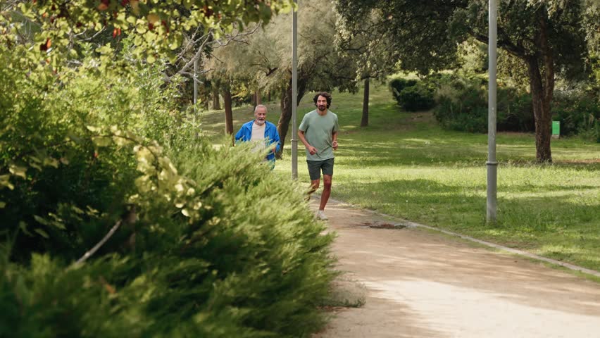Senior dad man jogging doing sport together with his son, running for healthy lifestyle and family bonding