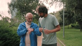 Senior father and son jogging doing sport together, checking cardio levels using smartwatch app after running in the morning - Powered by Shutterstock - Get 15% off with code: PIKWIZARD15