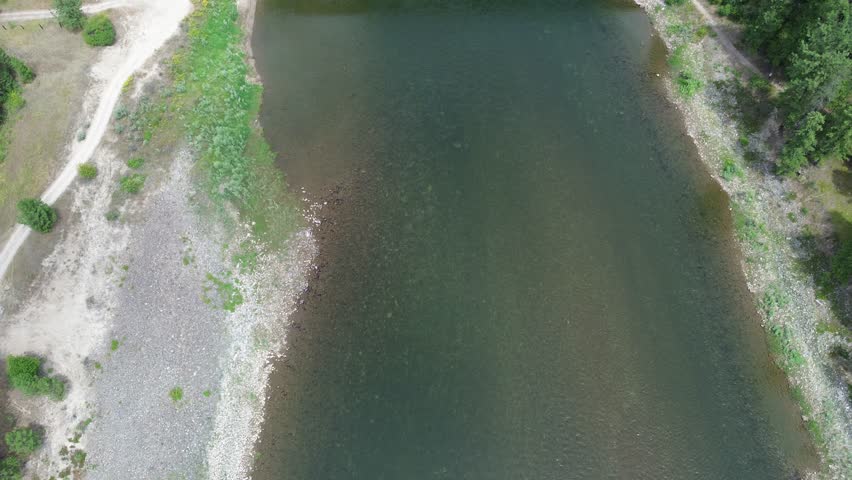 Railroad bridge over Clark Fork River in Montana. Unusual design is due to additional reinforcing structure to carry heavier trains. High angle flyover of the bridge.
