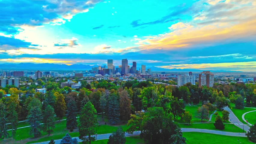 Drone Video of Cheesman Park and Denver Downtown Skyline in Colorado. The 4K footage highlights the Rocky Mountains at sunset. 