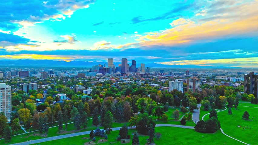 Drone Video of Cheesman Park and Denver Downtown Skyline in Colorado. The 4K footage highlights the Rocky Mountains at sunset. 